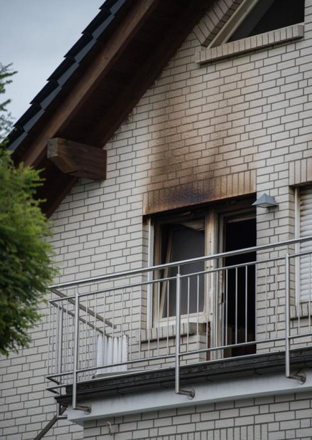 Brandspuren sind auf der Fassade des Einfamilienhauses zu sehen, in dem die Leichen der zwei Kinder im Alter von 10 und 13 Jahren geborgen wurden. Foto: dpa/Silas Stein