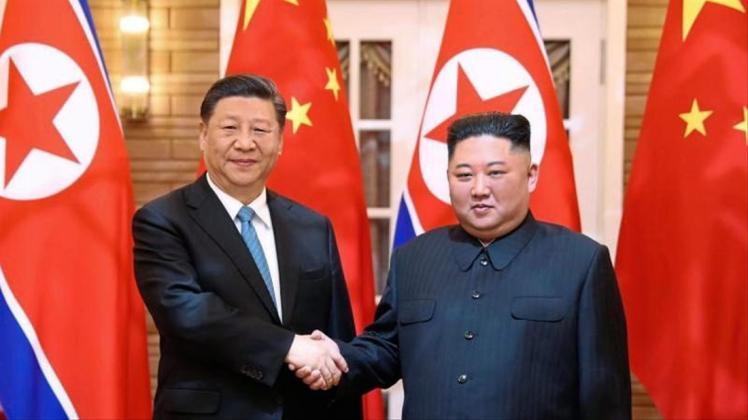 Xi Jinping (l.), Präsident von China, und Kim Jong Un, Machthaber von Nordkorea, beim Handshake. 