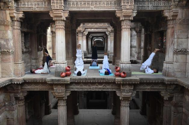 In Indien machten Zehntausende am Freitag Yoga bei einer Massenveranstaltung. Diese paar Yogis machten die Übungen lieber in Adalaj, in einem Palast aus dem 15. Jahrhundert. Foto: AFP/SAM PANTHAKY