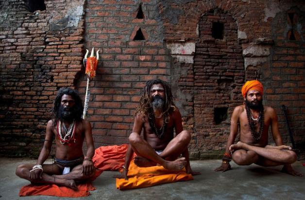 Indische Sadhus, hinduistische Heilige, machen Yoga-Übungen an einem Tempel. Foto: dpa/Anupam Nath/AP