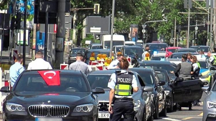 Eine Polizistin steht vor den Fahrzeugen eines türkischen Hochzeutskorsos. Der Konvoi war einer von dreien, den die Polizei in der Rheinmetropole am Wochenende angehalten hat. 