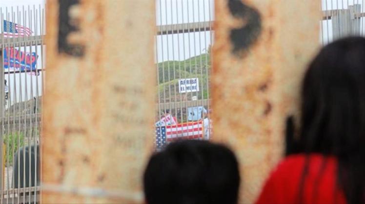 Blick nach drüben: Mexikanische Kinder beobachten durch den Grenzzaun Trump-Anhänger, die eine Verstärkung der Mauer fordern. 