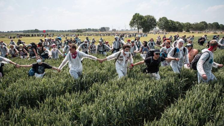 Klimaaktivisten des Bündnisses "Ende Gelände" stürmen bei ihren Demo am Tagebau Garzweiler über ein Feld.
