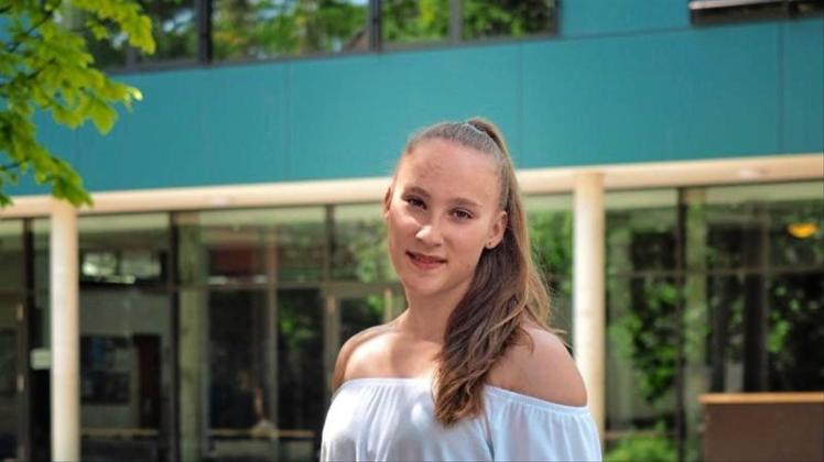 Niedersachsens jüngste Abiturientin Mandy Hoffmann steht mit einem Blumenstrauss in der Hand vor ihrer Schule. Mandy hat mit 14 Jahren das Abitur mit der Note 1,0 bestanden. 