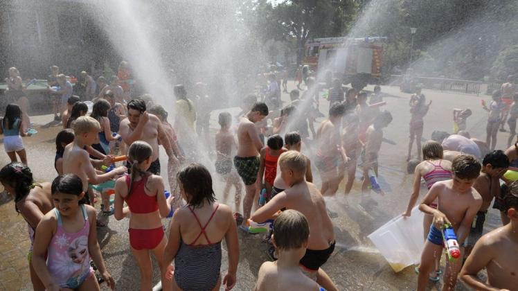 Die Feuerwehr Hagen hat bei Temperaturen von 30 Grad für Abkühlung an der Sankt Martin Grundschule im Ortszentrum gesorgt. Ein "Hydroschild" sorgte für großflächigen Sprühregen. Außerdem waren alle Schüleriinnen und Schüler mit Wasserspritzen jeglicher Art ausgerüstet. Nachdem der Tank des Feuerwehrfahrzeuges schnell leer gespritzt war, legte die Feuerwehr noch eine lange Schlauchleitung zum nächsten Hxdranten, um die Wasserversorgung wieder herzustellen. Foto: Gert Westdörp