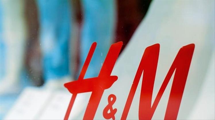Das Logo der Bekleidungskette Hennes und Mauritz (H&amp;M) klebt am Schaufenster einer Filiale am Kurfürstendamm in Berlin. Foto:  Hauke-Christian Dittrich