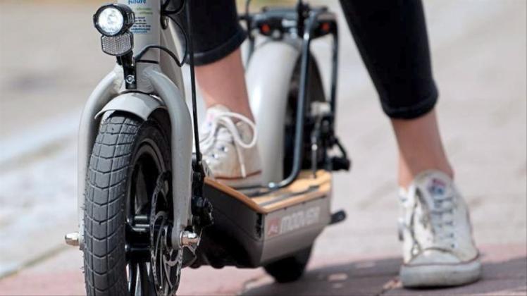 Eine Frau macht auf einem E-Scooter „Metz Moover“ vor dem Geschäft von efuture eine Probefahrt. 