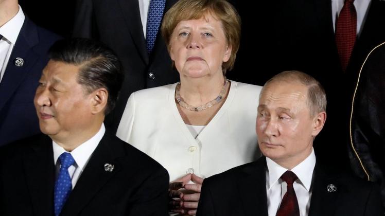Liberal versus illiberal: Kanzlerin Angela Merkel zwischen Chinas Präsident Xi Jinping und Russlands Staatschef Wladimir Putin beim G20-Gipfel in Osaka. Foto: Dominique Jacovides/POOL/AFP