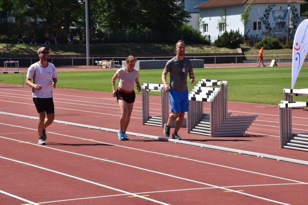 Begleitet von den ersten Zieleinläufern Malte Adelmann (l.) und Paul Stoll rennt Gudrun Berkholz (77) die letzten drei Runden des 3000-Meter-Laufs unter dem Applaus der Zuschauer im Leichtathletikstadion. Begleitet von den ersten Zieleinläufern Malte Adelmann (l.) und Paul Stoll rennt Gudrun Berkholz (77) die letzten drei Runden des 3000-Meter-Laufs unter dem Applaus der Zuschauer im Leichtathletikstadion.