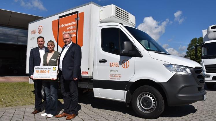 Der Verkaufsleiter vom Autohaus Sternauto Jens Wichmann (l.) und Fred Kretschmann (r.) vom Lebensmittelkonzern Lidl unterstützen die Rostocker Tafel und deren Leiterin Beate Kopka mit einem Kühlfahrzeug.