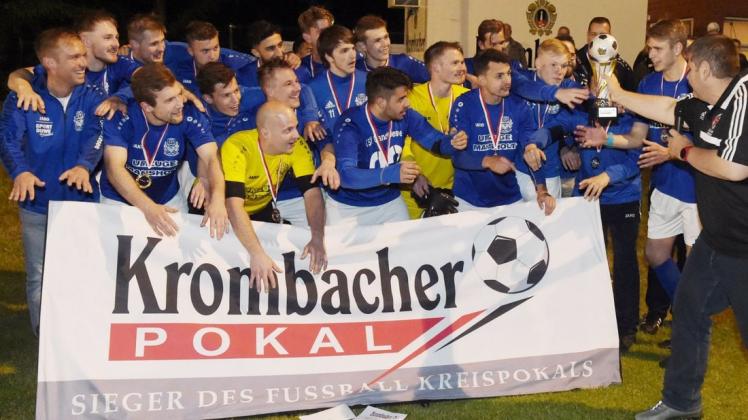 Da ist die Trophäe: Michael Koch, 2. Vorsitzender des Fußball-Kreises Oldenburg-Land/Delmenhorst (rechts), überreicht den Kreispokal an den TSV Ganderkesee. Foto: Rolf Tobis