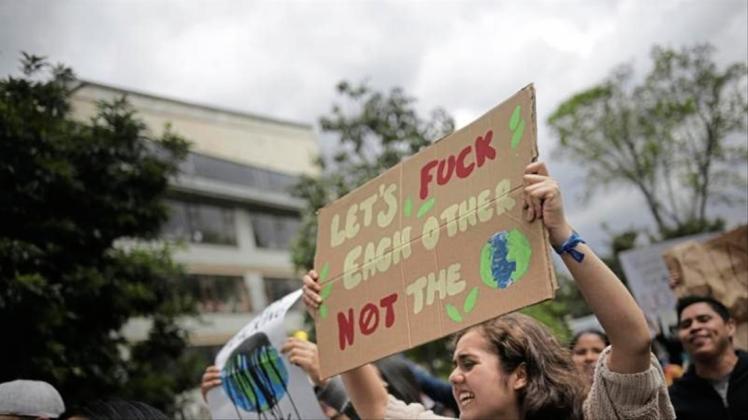 „Let&apos;s fuck each other, not the planet“, steht auf dem Plakat einer Demonstrantin bei „Fridays for Future“. 