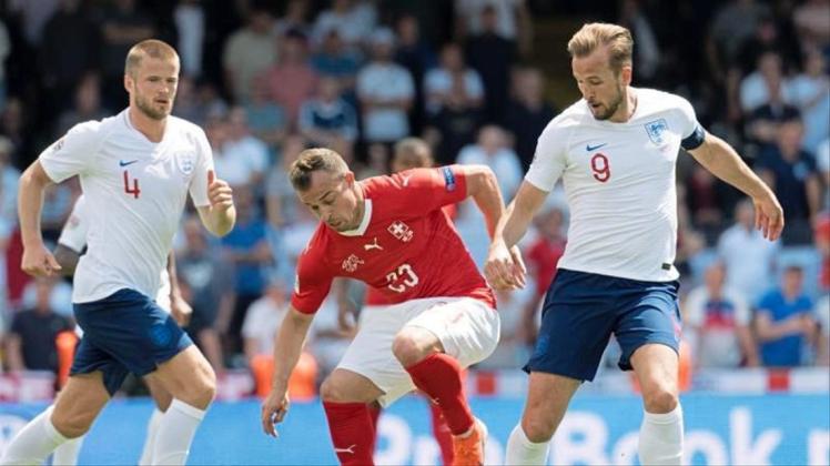 Xherdan Shaqiri (M) aus der Schweiz im Zweikampf mit Harry Kane. 