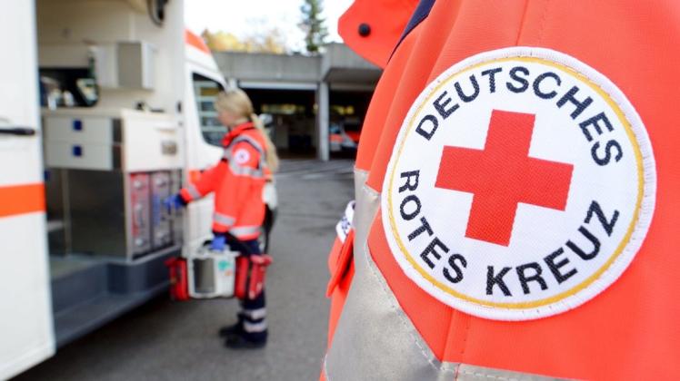 Eine Rettungssanitäterin steht vor einem Rettungswagen des Deutschen Roten Kreuzes. Foto: Bernd Weissbrod/dpa