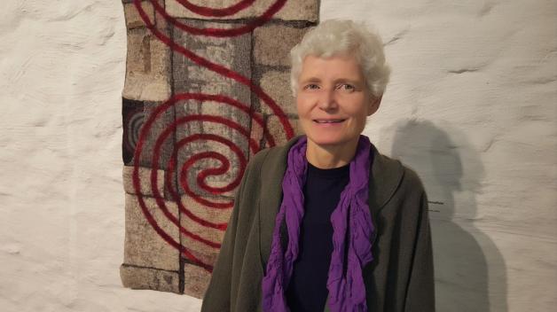 Künstlerin Mechtildis Köder vor ihrem Werk "Lebensfluss" aus dem Jahr 2013, das nun im Tuchmacher-Museum gezeigt wird. Foto: Bettina Mundt