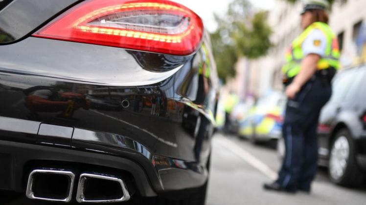 Polizeibeamte kontrollieren sogenannte Autoposer. Foto: Uwe Anspach/dpa