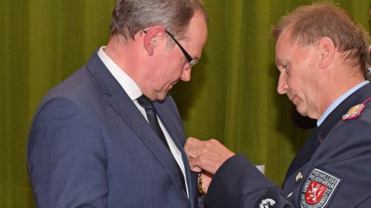 Ungewohnt für Bürgermeister Ansgar Pohlmann: statt andere zu ehren, heftet ihm Stadtbrandmeister Gerhard Glane eine Auszeichnung an die Brust.