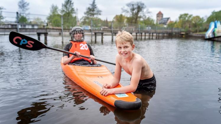 Mutig: Als einer der ersten Badegäste traut sich der elfjährige Finley Luca (r.) in das 15 Grad kalte Warnowwasser im Rostocker Flussbad. Kanupolo-Spieler Jannes (14) gibt Besuchern Einblicke in seine Sportart.