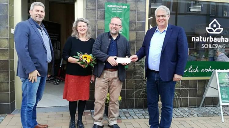 Stadtmanager Helge Schütze (links) und Bürgermeister Stephan Dose begrüßten zur Eröffnung vom „Naturbauhaus Schleswig“ Arne Bauer und seine Frau Sabine Bauer.