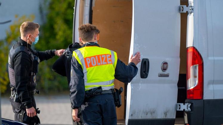 Zwei Polizisten kontrollieren auf der Grenzbrücke zwischen Deutschland und Polen ein Fahrzeug nach illegalen Einreisenden.