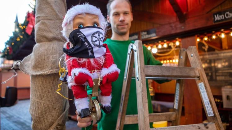 Der radelnde Nikolaus am Markt bekommt für das Foto noch schnell eine Maske aufgesetzt, bevor er von Peter-Marcel Hartmann auf sein Drahtseil gesetzt wird.