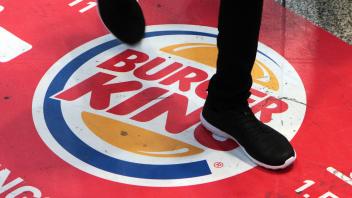 Werbung mit Logo Burger King mit Passanten auf dem Fußboden im Hauptbahnhof München Bayern Deutsch