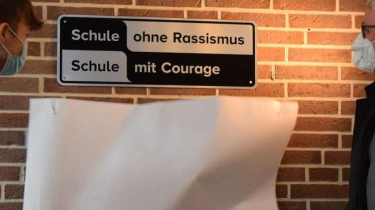 Zack, da war das Bekenntnis enthüllt: Schüler Ivan Hiebsch und der Projekt-Pate, Bundestagsabgeordneter Sönke Rix, legten am Montag das Schild "Schule ohne Rassismus - Schule mit Courage" im Foyer frei.