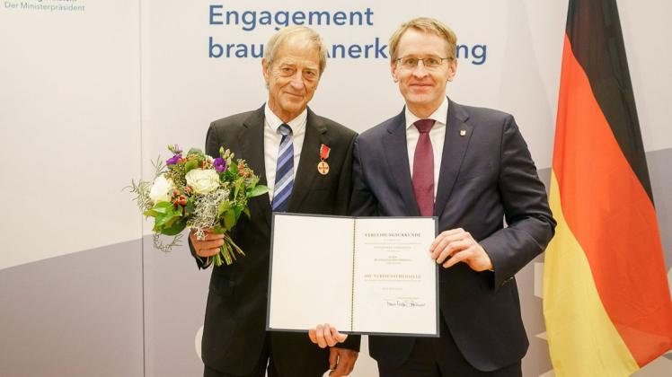 Ministerpräsident Daniel Günther händigt die Verdienstmedaille an Dr. Hans-Joachim Commentz (l.) aus.