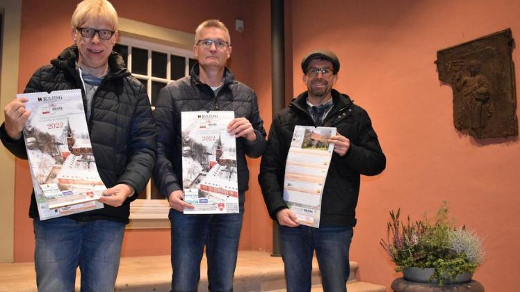 Er ist wieder da: Gemeinsam halten Kolping-Vorsitzender Ulrich Imwalle (Mitte) sowie die Kalendermacher Sebastian Hüdepohl (links) und Bernard vor dem Brocke die ersten frisch gedruckten Kalender-Exemplare für 2022 in den Händen.