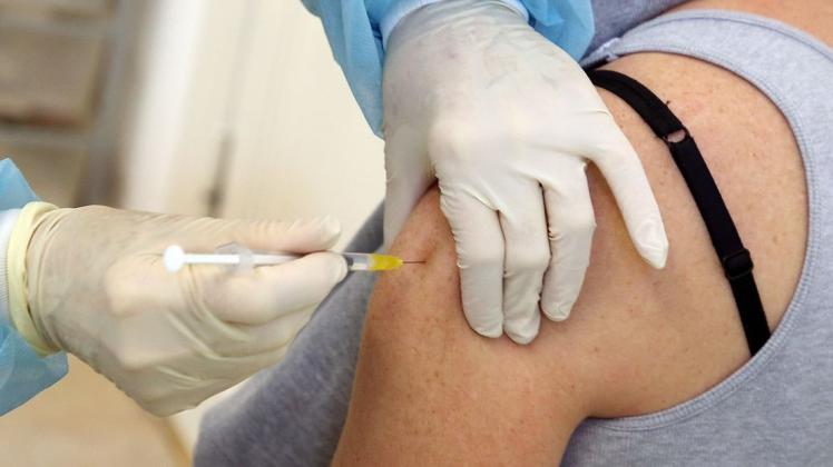 Eine Frau bekommt in einer Praxis ihre Booster-Impfung verabreicht.