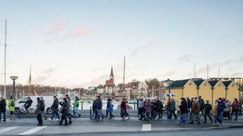 Sorgen sich nach eigenen Aussagen um die Demokratie: mehrere hundert Gegner spazieren am Flensburger Hafen gegen die Coronamaßnahmen an.