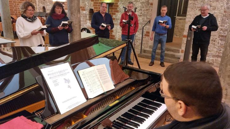 Unter der Leitung von Kantor Christian Wiebeck (vorn) werden die musikalischen Teile der Weihnachtsgeschichte im Refektorium der Klosterkirche Dobbertin aufgenommen.