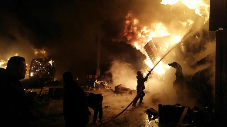 Flammen steigen aus den Containern: Feuerwehrleute versuchen das große Feuer zu löschen. Flammen steigen aus den Containern: Feuerwehrleute versuchen das große Feuer zu löschen.