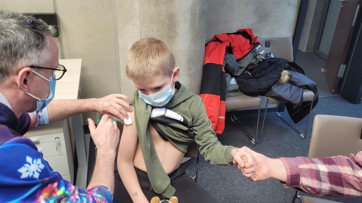 Gesundheits- und Krankenpfleger René Anders verabreicht Jake seine erste Impfung gegen Corona. Tapfer erträgt der Siebenjährige die kurze Prozedur.