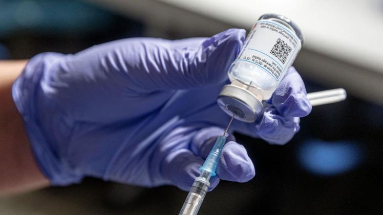 Eine Krankenschwester zeiht Corona-Impfstoff aus einer Ampulle in eine Spritze auf. (Archivbild)