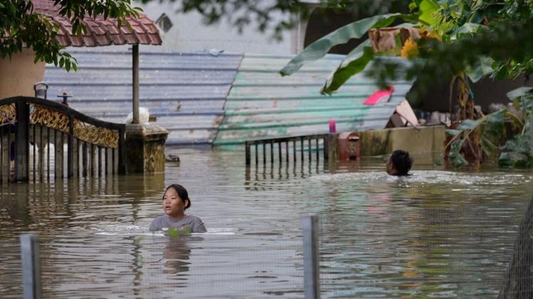 Nach Monsunregen in Malaysia: In Kuala Lumpur waten Menschen durch überflutete Straße.