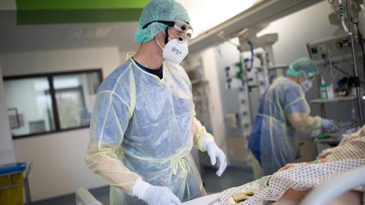 Intensivpflegekraft Matthias Nöring dreht eine Patientin, die beatmet werden muss, auf den Bauch. Die Bauchlagerung hilft, Corona-Patienten mit schwächelnder Lunge mit Sauerstoff zu versorgen.