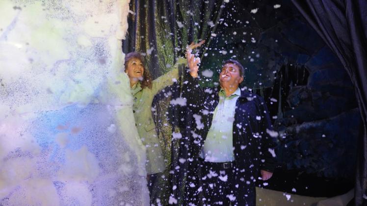 Es schneit! Torneschs Bürgermeisterin Sabine Kählert und Rolf Heidenberger von „Appen musiziert“ freuen sich über die weiße Pracht, die von der weihnachtlich geschmückten Theaterbühne herabrieselt.
