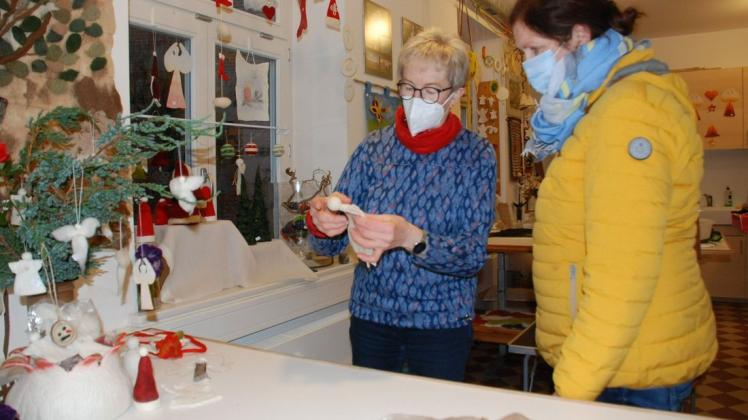 Sibylle Hoppe (l.) vom Filzverein Lenzen zeigt Kerstin Mensch aus Babekuhl einen kleinen Filzengel.