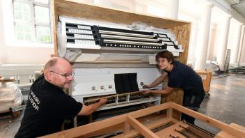 Montage-Leiter Stefan Hilgendorf und die Auszubildende Natalia Hirschmann mit einem Teil der neuen Orgel.