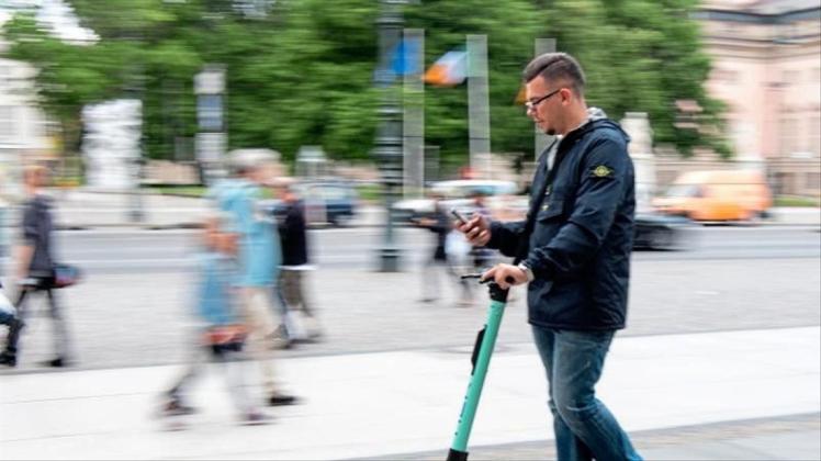 Auf zwei winzigen Rädern im Innenstadtverkehr, die Augen fest aufs Handy geheftet: Ein Tourist fährt durch Berlin-Mitte. 