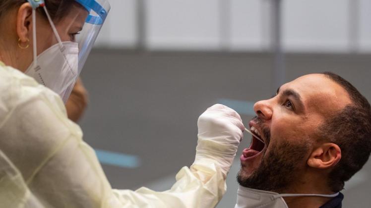 Eine Mitarbeiterin nimmt in einem Corona-Testzentrum einen Rachenabstrich für einen Corona-Schnelltest ab. Interessierte können sich einmal pro Woche unentgeltlich auf das Coronavirus testen lassen.