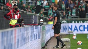 Drei Mal VAR: Daniel Siebert prüft die Entscheidung zum Handelfmeter und lässt sich nach Ansicht der Bilder überzeugen. Er sah die Hand von Julian Riedel bei einer Werder-Flanke strafbar am Ball.