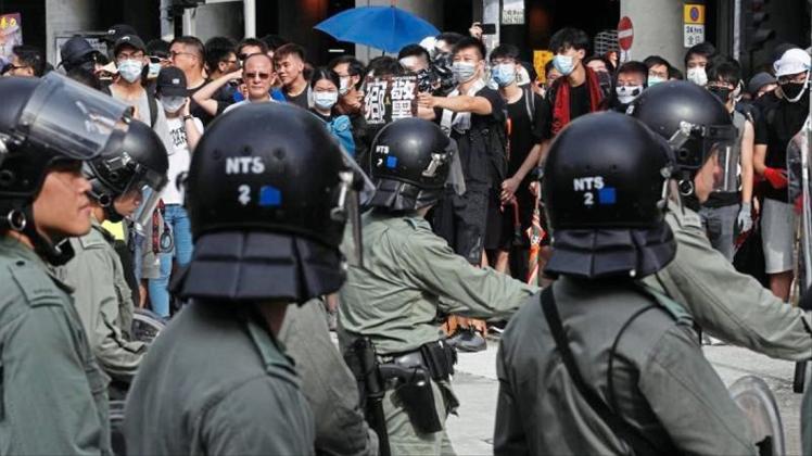 Bereitschaftspolizisten stehen Demonstranten bei dem Protest im Bezirk Yuen Long gegenüber. 