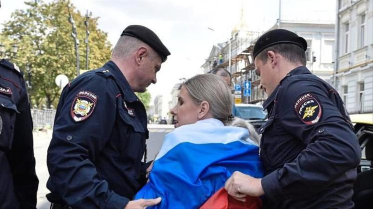 Russische Polizeibeamte verhaften eine Oppositionelle bei der nicht genehmigten Kundgebung im Zentrum der Stadt. Nach den Massenfestnahmen bei den Protesten in der russischen Hauptstadt Moskau sind mehr als 40 Demonstranten zu Arreststrafen verurteilt worden. 