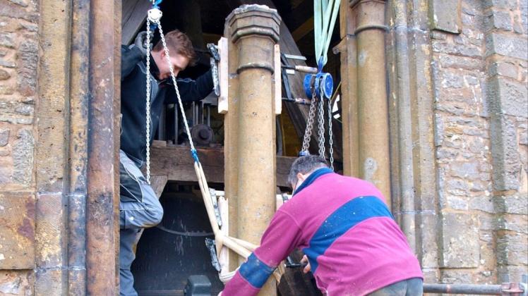 Jetzt schwebt sie raus: Mit vereinten Kräften heben die Steinmetze Malte Roß (links) und Andreas Strotmeyer die Sandsteinsäule aus der Fensteröffnung. Fotos: Conny Rutsch