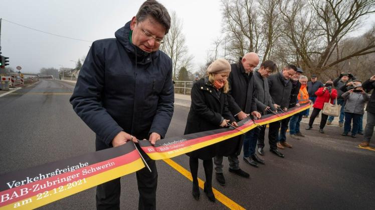Freie Fahrt auf der B 321 in Schwerin: Verkehrsminister Reinhard Meyer (l.) schneidet nach vier Jahren Bauzeit am 22. Dezember gemeinsam mit weiteren Akteuren das symbolische Band für die Verkehrsfreigabe durch.