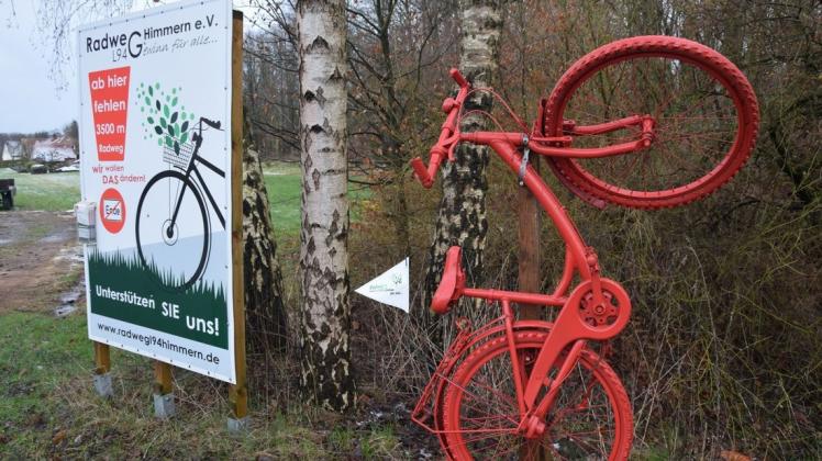 Zwei Symbole, die auf den notwendigen Bau des Radweges entlang der Wellingholzhausener Straße aufmerksam machen: Rote Fahrräder und große Hinweistafeln. Foto: Simone Grawe