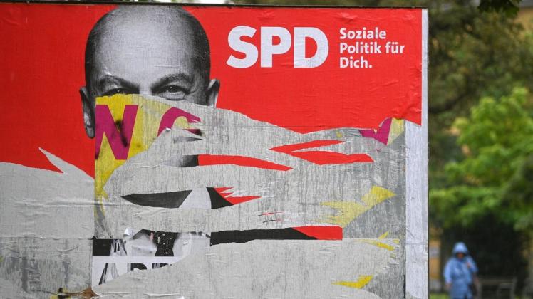 Ein zerstörtes Wahlplakat mit dem Portrait von Olaf Scholz, Kanzlerkandidat der SPD.