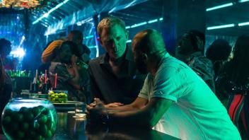 In allen Verfilmungen auch trinkfest: Daniel Craig als James Bond und Jeffrey Wright (r.) als Felix Leiter in einer Szene des Films „James Bond 007 - Keine Zeit zu sterben“.